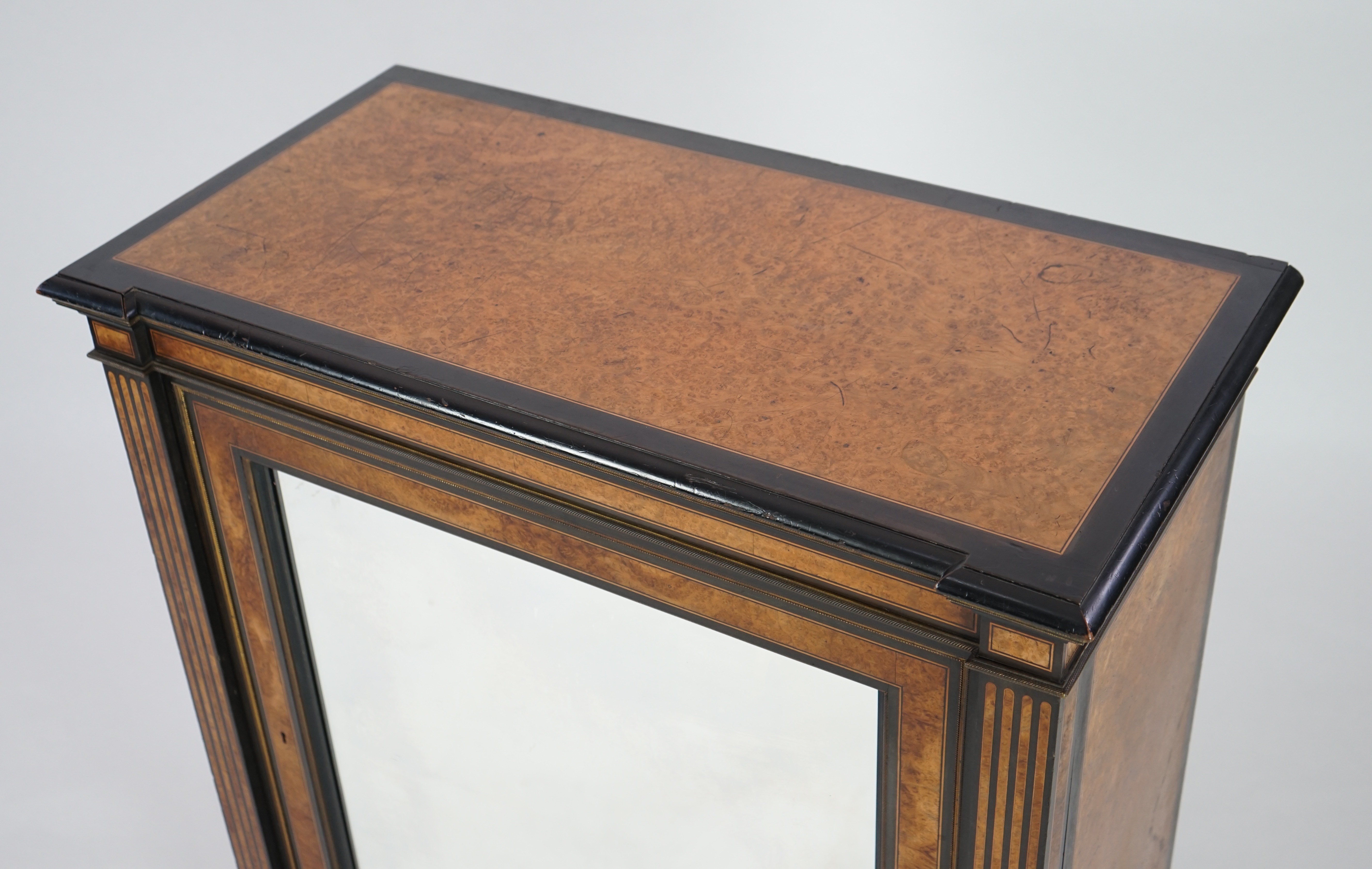 A Victorian ebony banded amboyna wood collector's cabinet, by Holland & Sons, with inverted breakfront top and single mirrored door enclosing four frieze and two banks of thirteen graduated drawers fitted with recessed b